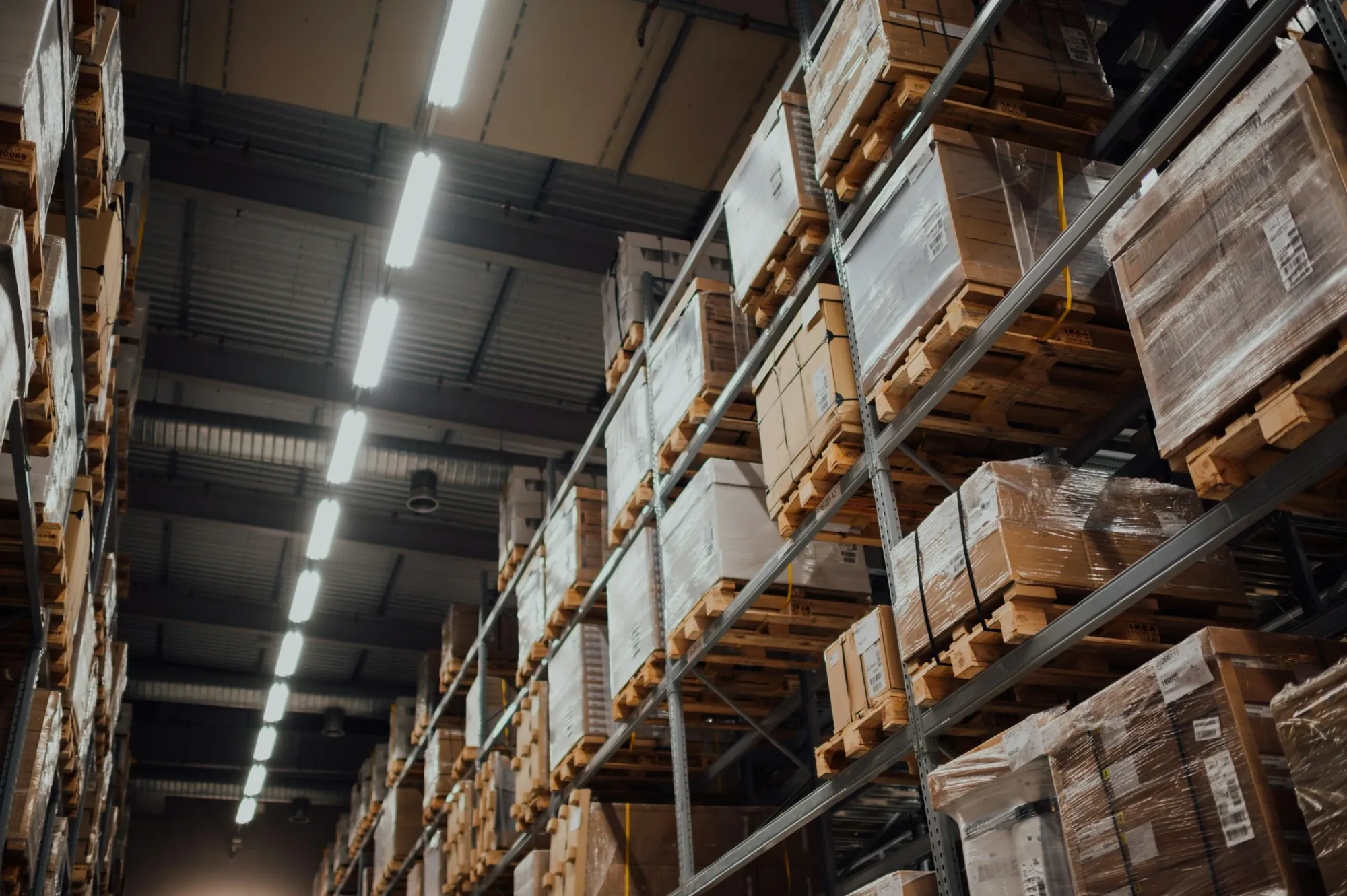 Warehouse racks with pallets of shrink-wrapped boxes
