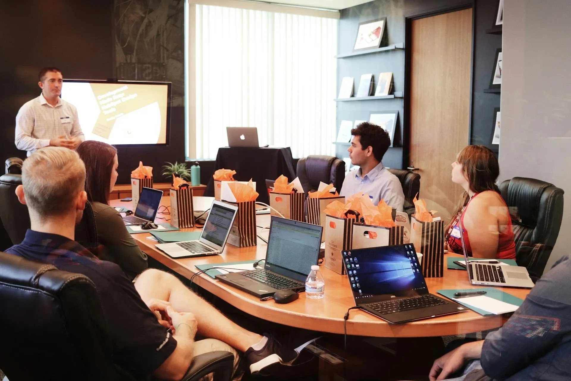 Equipo de trabajo reunido alrededor de una mesa con computadoras